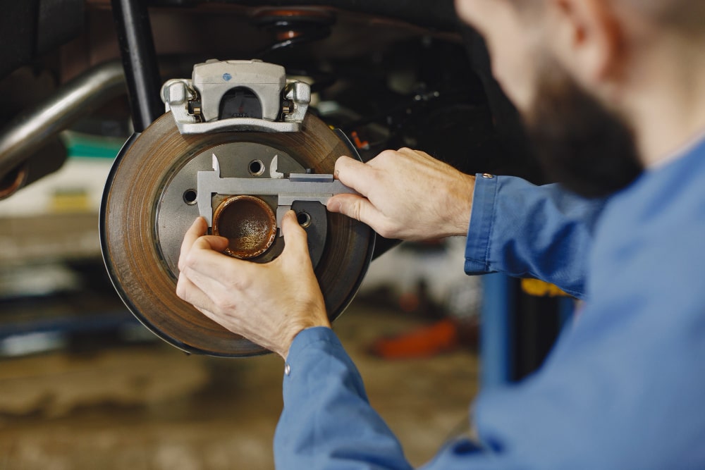 mechanic-with-tool-wheel-hands-mechanic-blue-work-clothes-min